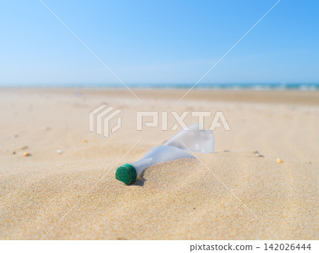 Plastic bottle on the beach. Plastic trash buried in the sand. Plastic bottle on the beach. Plastic trash buried in the sand. 142026444