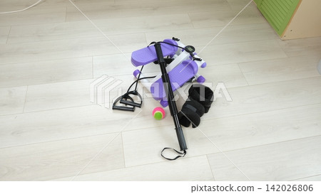 Sport Home exercise equipment. Efficient workout routine. Fitness gear placed for home fit. Yoga mat, roller, dumbbells on room floor ready for recovery session. Personal inventory for weight loss Sport Home exercise equipment. Efficient workout routine. Fitness gear placed for home fit. Yoga mat, roller, dumbbells on room floor ready for recovery session. Personal inventory for weight loss 142026806