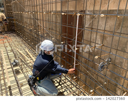 A site supervisor measures and inspects the dimensions of the rebar. A site supervisor measures and inspects the dimensions of the rebar. 142027360
