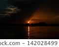 Sun eclipses 2026. Bright crescent sun dips toward Denia coastline with orange reflection on the sea 142028499