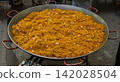 Massive paella pan filled with fideua and seafood at a market gathering during day 142028504
