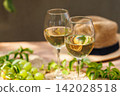 Closeup of white wine glasses and grapes on summer table.. 142028518