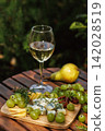 Chilled White Wine and Fresh Grapes in Garden Ambience 142028519
