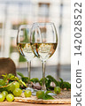 Chilled White Wine Glasses with Grapes on Outdoor Table 142028522