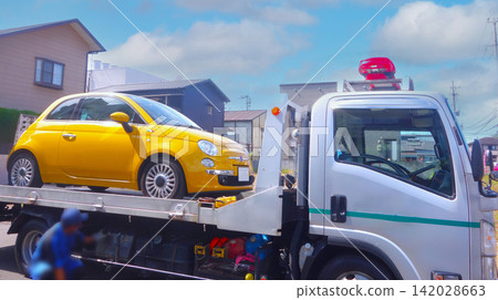 一輛黃色義大利轎車因無法行駛而被路邊救援車拖走。 一輛黃色義大利轎車因無法行駛而被路邊救援車拖走。 142028663