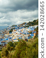 Blue hillside city under cloudy sky Blue hillside city under cloudy sky 142028665