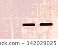 Minimalist background material featuring a pale pink concrete wall and slit openings. 142029025