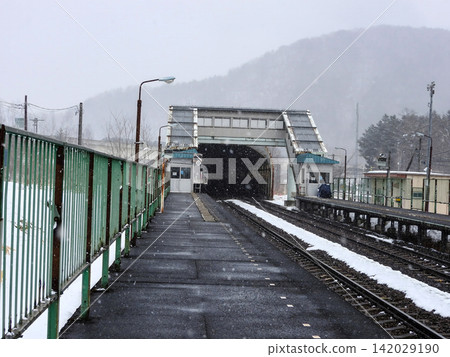 A snow-covered, unmanned train station platform and the tracks stretching out before you – an image of winter travel. A snow-covered, unmanned train station platform and the tracks stretching out before you – an image of winter travel. 142029190