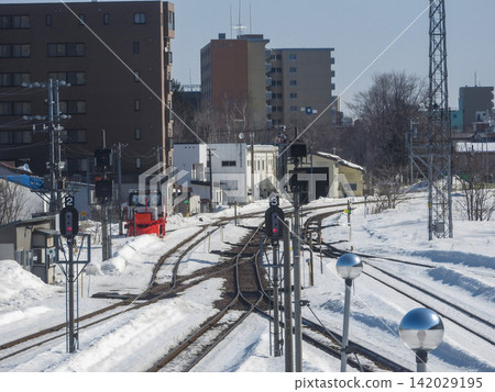 Snow-covered railway tracks and facilities (sunny day, winter station premises) Snow-covered railway tracks and facilities (sunny day, winter station premises) 142029195