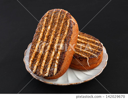 hazelnut Chocolate Oval Cake Pastry with Icing Stripes Isolated on White Background hazelnut Chocolate Oval Cake Pastry with Icing Stripes Isolated on White Background 142029670