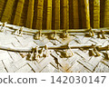 The woven wooden walls and rope decorations of the ancient dwelling are illuminated in golden light. 142030147