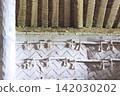 The interior of the reconstructed dwelling features woven wooden walls and rope decorations. 142030202