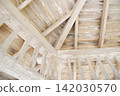 A wooden attic structure with exposed beams and ceilings. 142030570