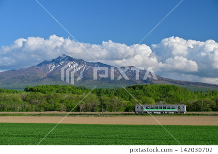 A Series H100 train running on the Senmo Main Line with Mount Shari in the background. A Series H100 train running on the Senmo Main Line with Mount Shari in the background. 142030702