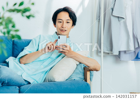 看他的智能手機的一個年輕人 142031157