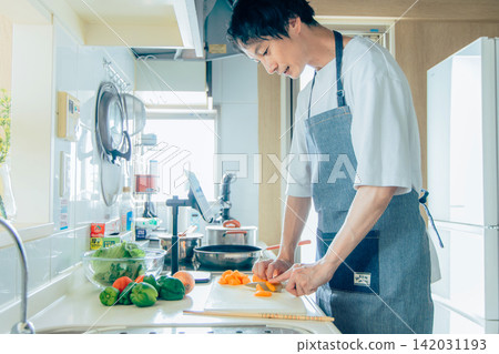 A young man cooking A young man cooking 142031193