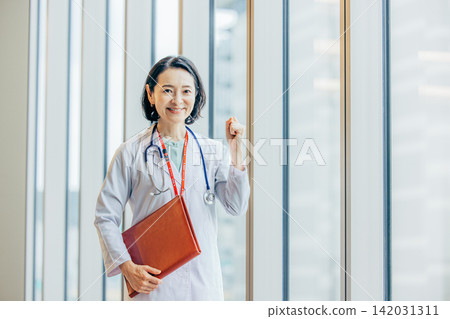 一位五十多歲的女醫生身穿白大褂的肖像。 一位五十多歲的女醫生身穿白大褂的肖像。 142031311