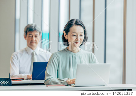 在辦公室的電腦上工作的商務人士 在辦公室的電腦上工作的商務人士 142031337