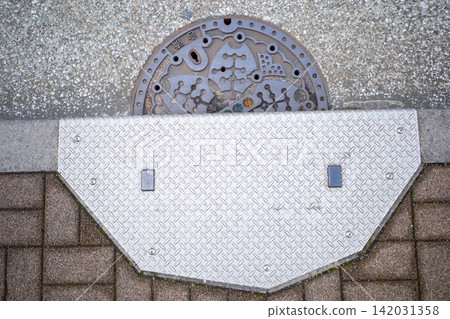 Manhole embedded in the road Manhole embedded in the road 142031358