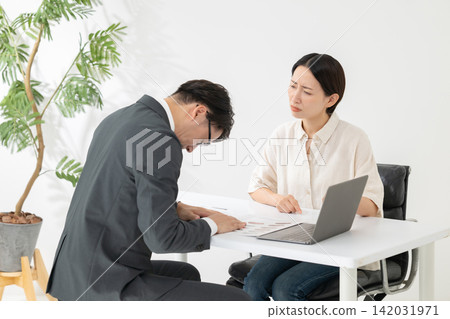 A businessman and a woman apologizing A businessman and a woman apologizing 142031971