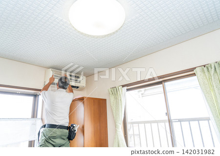 Air conditioner cleaning; a man from the air conditioner maintenance company. Air conditioner cleaning; a man from the air conditioner maintenance company. 142031982