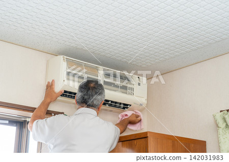 Air conditioner cleaning; a man from the air conditioner maintenance company. Air conditioner cleaning; a man from the air conditioner maintenance company. 142031983