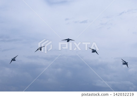 A formation of C-2 transport planes flying through a cloudy sky. A formation of C-2 transport planes flying through a cloudy sky. 142032219