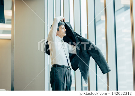 Senior businessmen wearing suit jackets in the office Senior businessmen wearing suit jackets in the office 142032312