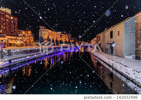 The historic Otaru Canal is bathed in the magical night light of falling snow and warm gas lamps. The historic Otaru Canal is bathed in the magical night light of falling snow and warm gas lamps. 142032406