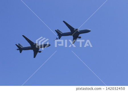 A formation of aerial refueling tankers flying through a clear blue sky. A formation of aerial refueling tankers flying through a clear blue sky. 142032450