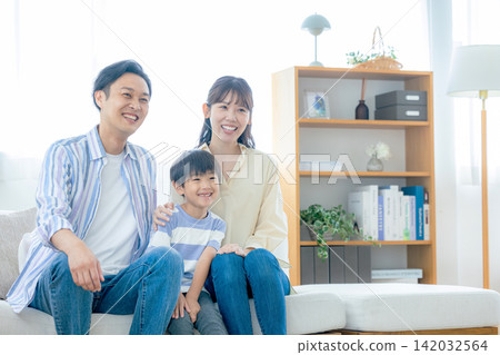 一個在客廳裡放鬆的年輕家庭 142032564