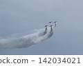Four Blue Impulse aircraft fly in formation against a gray sky. 142034021