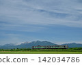 A Series H100 train running with the Tokachi Mountain Range in the background. 142034786