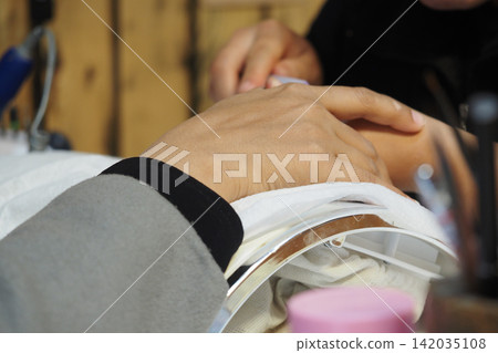 Customer receiving manicure at nail salon Customer receiving manicure at nail salon 142035108