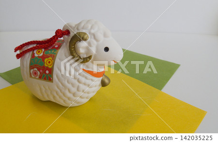 New Year's zodiac decorations: A sheep figurine for the Year of the Sheep and a traditional Japanese design using washi paper. New Year's zodiac decorations: A sheep figurine for the Year of the Sheep and a traditional Japanese design using washi paper. 142035225