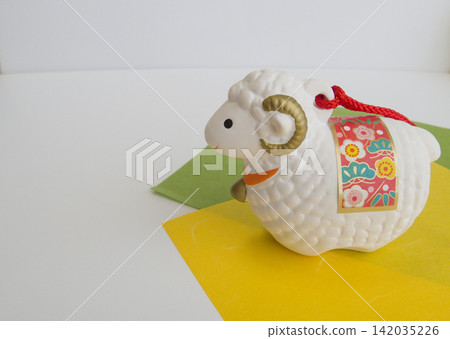 New Year's zodiac decorations: A sheep figurine for the Year of the Sheep and a traditional Japanese design using washi paper. New Year's zodiac decorations: A sheep figurine for the Year of the Sheep and a traditional Japanese design using washi paper. 142035226