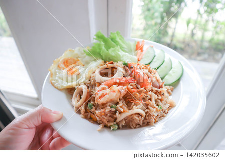 fried rice or stir-fried rice with shrimp , squid and fried egg or sunny side up egg fried rice or stir-fried rice with shrimp , squid and fried egg or sunny side up egg 142035602
