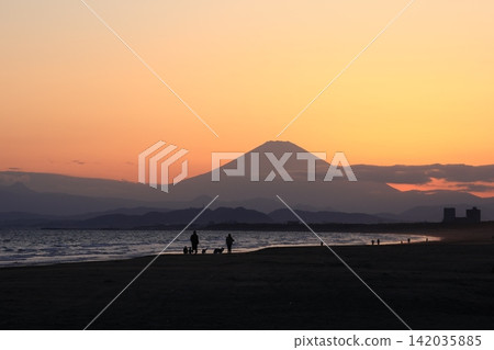 At Kugenuma Beach, the waves at the waterline are bathed in orange light after sunset, and the silhouette of Mount Fuji is visible. At Kugenuma Beach, the waves at the waterline are bathed in orange light after sunset, and the silhouette of Mount Fuji is visible. 142035885