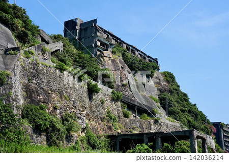 The concrete ruins of Hashima (Battleship Island), a World Heritage Site, surrounded by blue skies and greenery. The concrete ruins of Hashima (Battleship Island), a World Heritage Site, surrounded by blue skies and greenery. 142036214