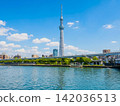 從隅田川上可以看到東京晴空塔和高架的首都高速公路，水面上漂浮著船屋。 142036513