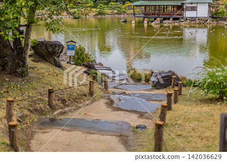 一條石板路通往池塘,池塘很大,水鳥在此嬉戲,旁邊還有一個涼亭。清澄花園,2024年3月。 一條石板路通往池塘,池塘很大,水鳥在此嬉戲,旁邊還有一個涼亭。清澄花園,2024年3月。 142036629