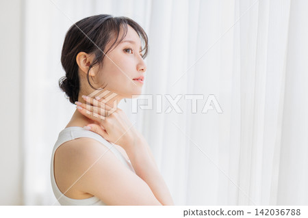 Beauty image: A young woman with her hand on her neck. 142036788