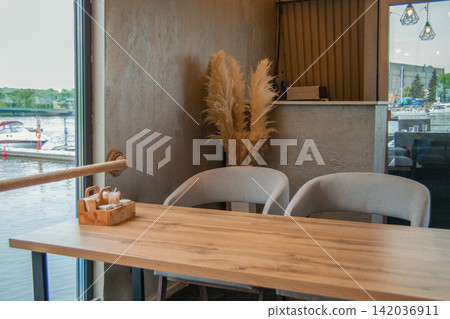 Stylish interior with chair and wooden table in yacht restaurant Stylish interior with chair and wooden table in yacht restaurant 142036911