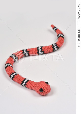 Crocheted Coral Snake Toy on White Surface 142037760