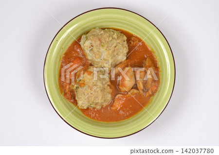 Chicken paprikash with bread dumplings in a green bowl Chicken paprikash with bread dumplings in a green bowl 142037780