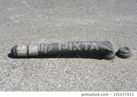 Flexible rubber bollard bent on asphalt street close up Flexible rubber bollard bent on asphalt street close up 142037815