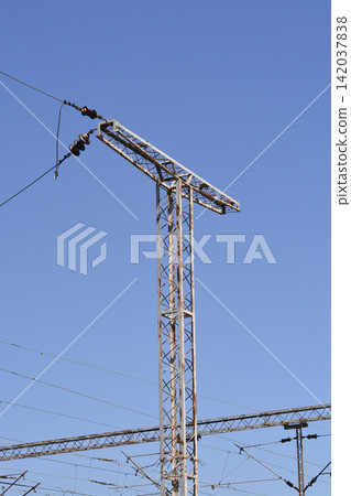 T shaped railway catenary steel mast against a blue sky T shaped railway catenary steel mast against a blue sky 142037838