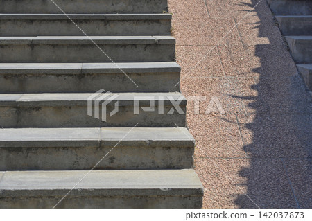 Outdoor concrete stairs with a stone stroller ramp and geometric shadows Outdoor concrete stairs with a stone stroller ramp and geometric shadows 142037873