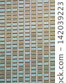 Mosaic tile wall with beige and blue ceramic rectangles creating geometric pattern 142039223