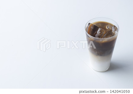 Two layers of iced café au lait, with a large white background on the left. Two layers of iced café au lait, with a large white background on the left. 142041050
